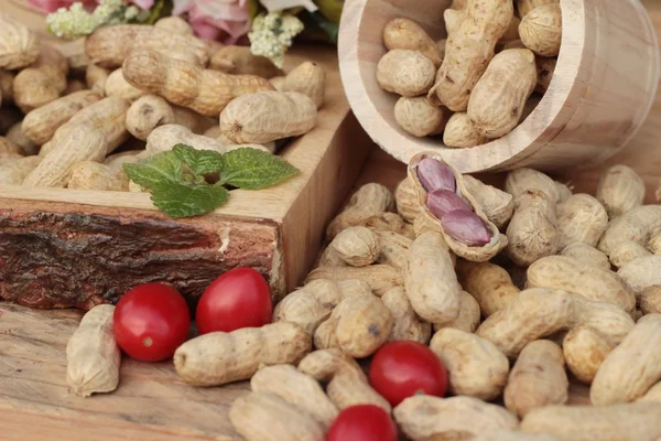 Cacahuetes y cacahuetes cocidos sobre fondo de madera . — Foto de Stock