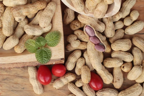 Peanut and boiled peanuts on wood background. — Stock Photo, Image