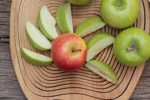 Zielone i czerwone jabłka na tle drewna — Zdjęcie stockowe