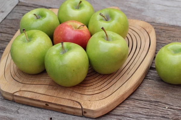 Manzanas verdes y rojas sobre fondo de madera . — Foto de Stock