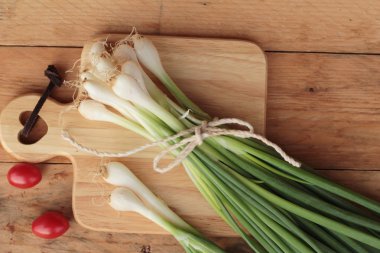 Ahşap arka plan üzerinde taze yeşil soğan