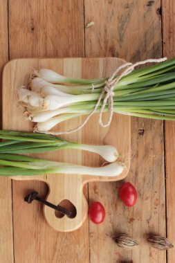 Ahşap arka plan üzerinde taze yeşil soğan
