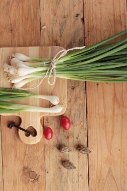 Ahşap arka plan üzerinde taze yeşil soğan