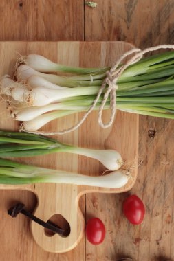 Ahşap arka plan üzerinde taze yeşil soğan