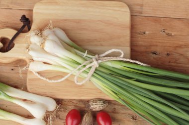 Ahşap arka plan üzerinde taze yeşil soğan