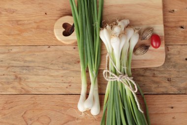 Ahşap arka plan üzerinde taze yeşil soğan