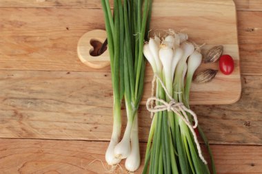Ahşap arka plan üzerinde taze yeşil soğan