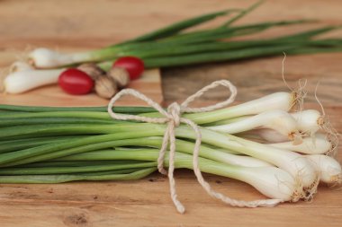 Fresh green onions on wood background clipart
