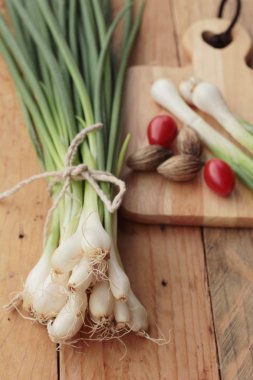 Ahşap arka plan üzerinde taze yeşil soğan