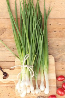 Ahşap arka plan üzerinde taze yeşil soğan