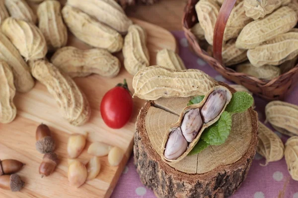 Peanut and boiled peanuts on wood background. — Stock Photo, Image