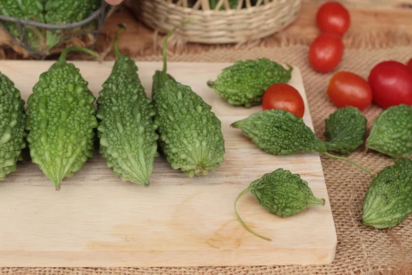 Melón amargo y rebanado sobre fondo de madera — Foto de Stock