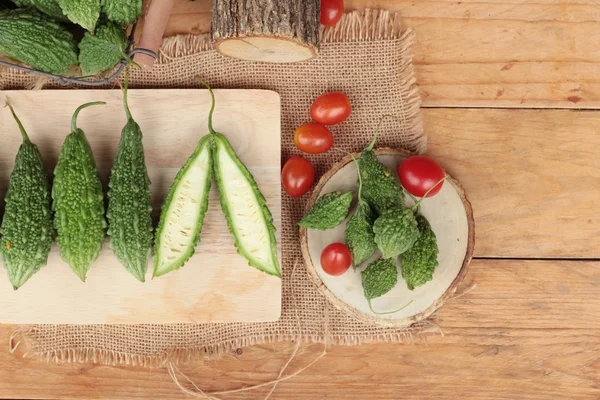 Bitter melon och skivad på trä bakgrund — Stockfoto