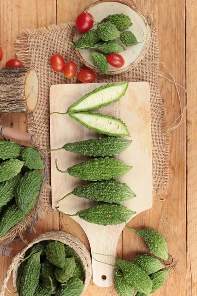 Melón amargo y rebanado sobre fondo de madera — Foto de Stock