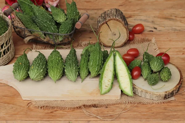 Bitter melon och skivad på trä bakgrund — Stockfoto