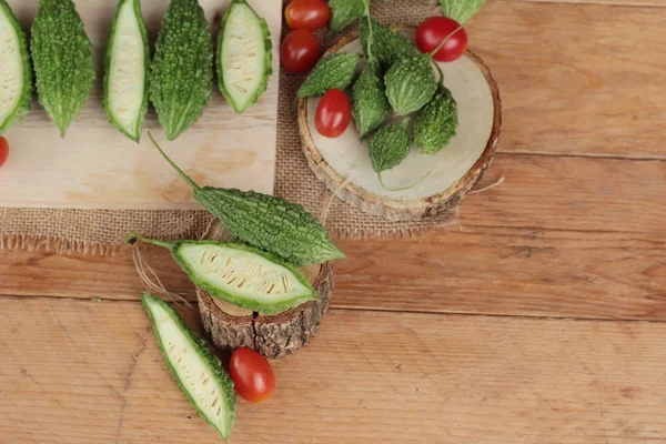 Bitter melon och skivad på trä bakgrund — Stockfoto