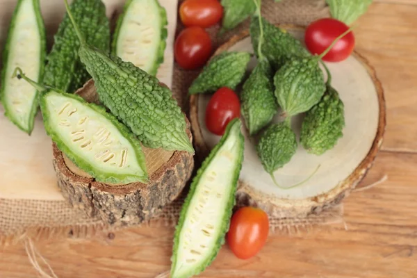 Bitter melon och skivad på trä bakgrund — Stockfoto