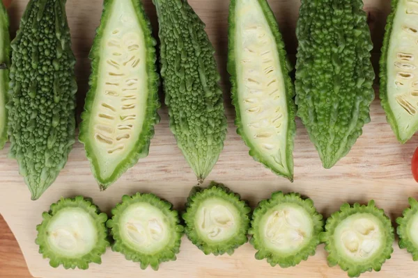 Melón amargo y rebanado sobre fondo de madera — Foto de Stock