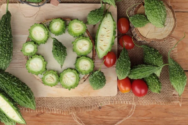 Bitter melon och skivad på trä bakgrund — Stockfoto