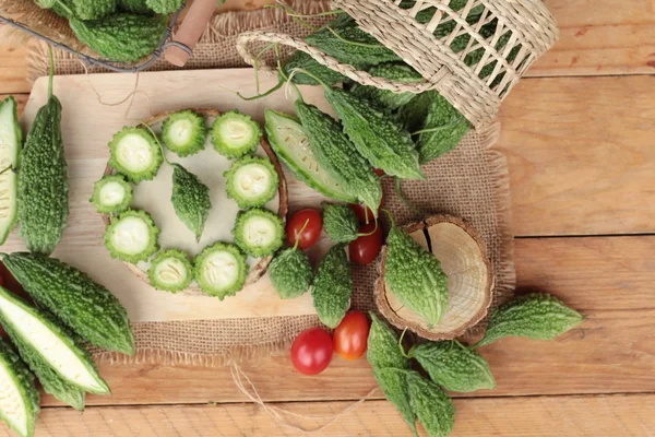 Bitter melon och skivad på trä bakgrund — Stockfoto