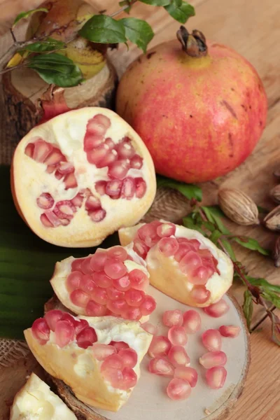 Fruta de romã madura deliciosa no fundo de madeira — Fotografia de Stock