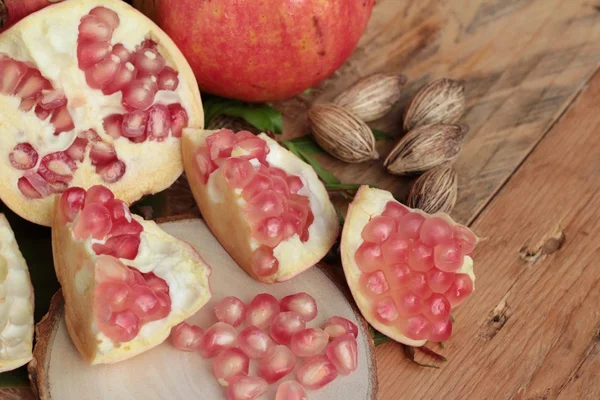 Fruta de romã madura deliciosa no fundo de madeira — Fotografia de Stock