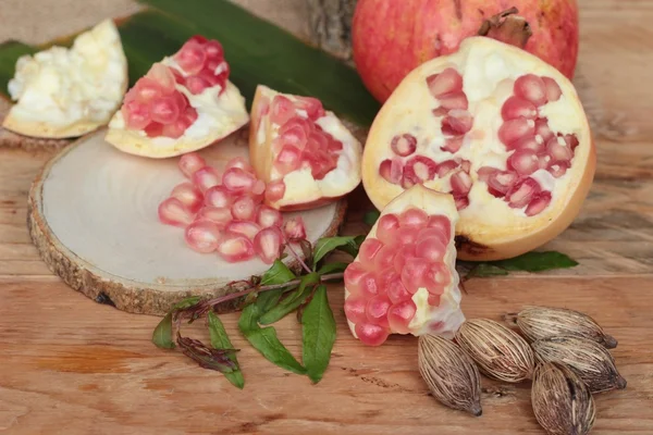Fruta de romã madura deliciosa no fundo de madeira — Fotografia de Stock