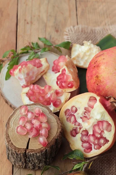 Fruta de romã madura deliciosa no fundo de madeira — Fotografia de Stock