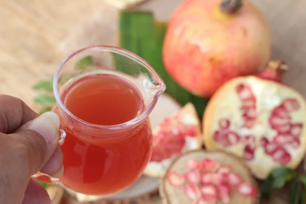 Ripe pomegranates with juice on wood background — Stock Photo, Image