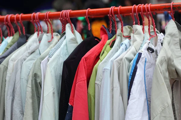 Shop shirts colorful fabric hanging on a rack. — Stock Photo, Image