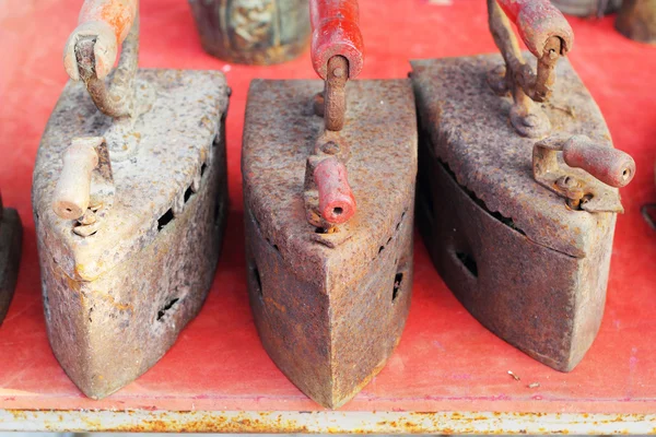 Antikes Eisen auf rotem Hintergrund angeordnet. — Stockfoto