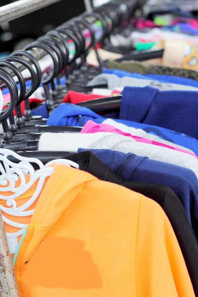 Shop shirts colorful fabric hanging on a rack. — Stock Photo, Image