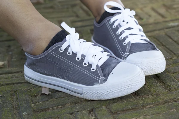 Graue Turnschuhe mit modellhaftem Lifestyle — Stockfoto