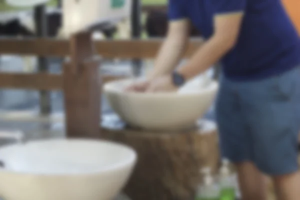 Un hombre lavándose las manos en un lavabo — Foto de Stock