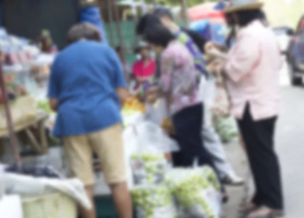 Pessoas desfocadas compram frutas no mercado . — Fotografia de Stock