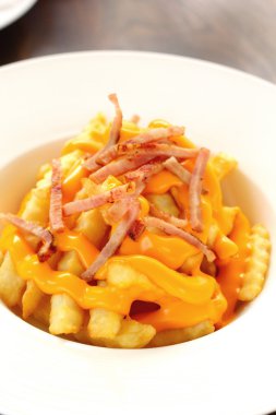 Plaka üzerinde peynir ile kızarmış patates tepesinde.