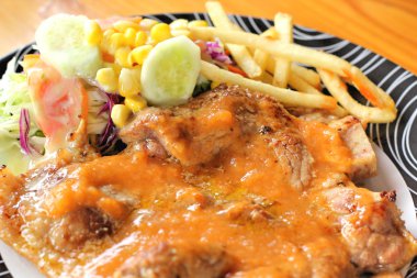 Biftek, patates kızartması bir tabakta sebze salatası ile.