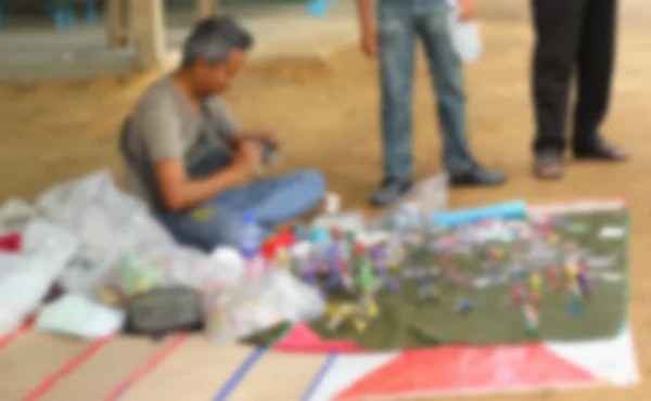 Homens desfocados vendendo brinquedos feitos à mão — Fotografia de Stock