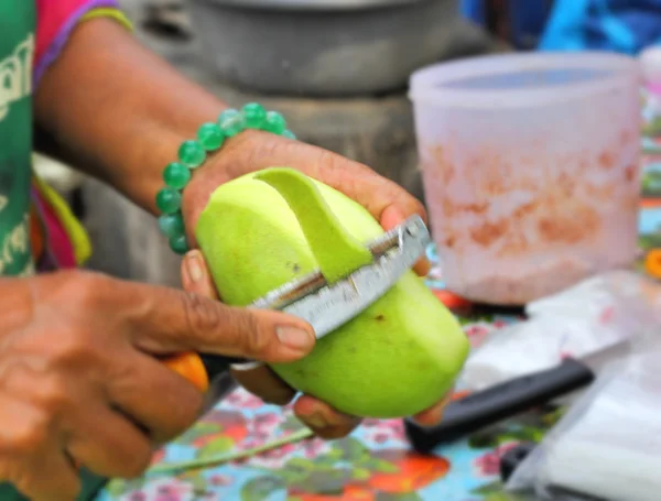 Femme faisant des tranches de mangue fraîche — Photo