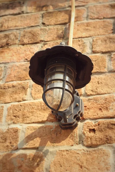 Gammal lampa brun tegelvägg. — Stockfoto