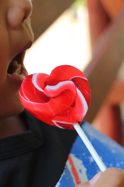 Мальчик ест конфеты Валентина сердца — стоковое фото