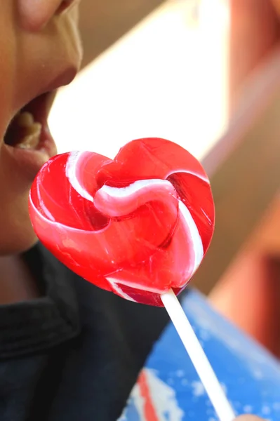 A boy eating candy valentines hearts — Stock Photo, Image