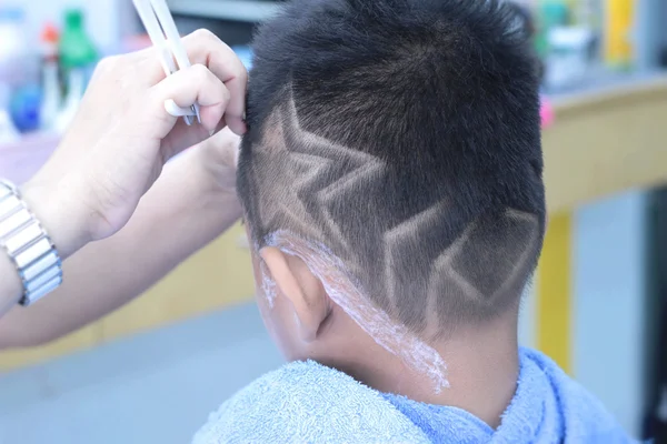 Strzyżenie chłopca z clipper i brzytwa w sklepie fryzjer — Zdjęcie stockowe