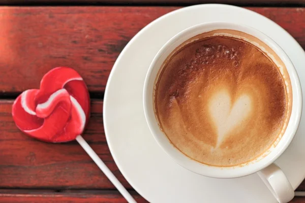 Gorące latte kawy w szkło i cukierki słodkie Walentynki serca — Zdjęcie stockowe