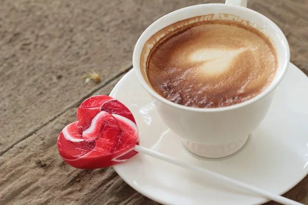 Hot latte coffee in glass and candy sweet valentines heart — Stock Photo, Image