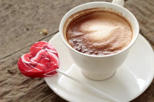 Heißer Latte-Kaffee im Glas und bonbonsüßes Valentinsherz — Stockfoto