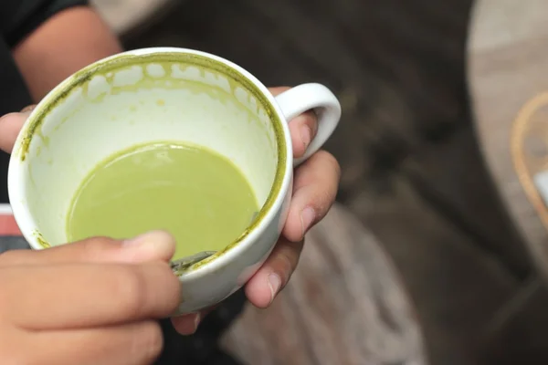 Gutten drikker grønn te og melk. . – stockfoto