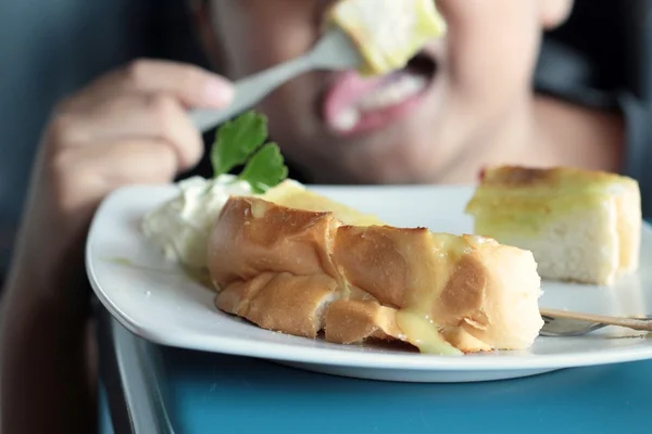 The boy eating bread, butter, topped with custard delicious — Stock Photo, Image