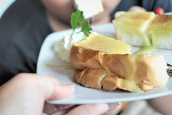 O menino comendo pão, manteiga, coberto com creme delicioso — Fotografia de Stock