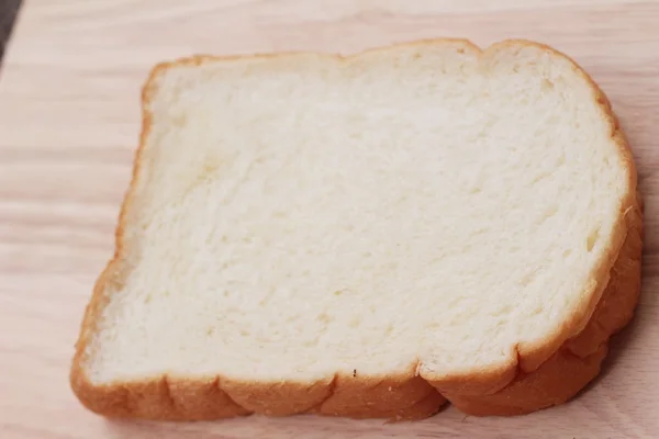 Slice of bread on wood background — Stock Photo, Image